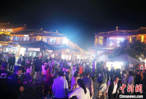 图为游客夜间游览丽江古城。黄兴鸿 摄