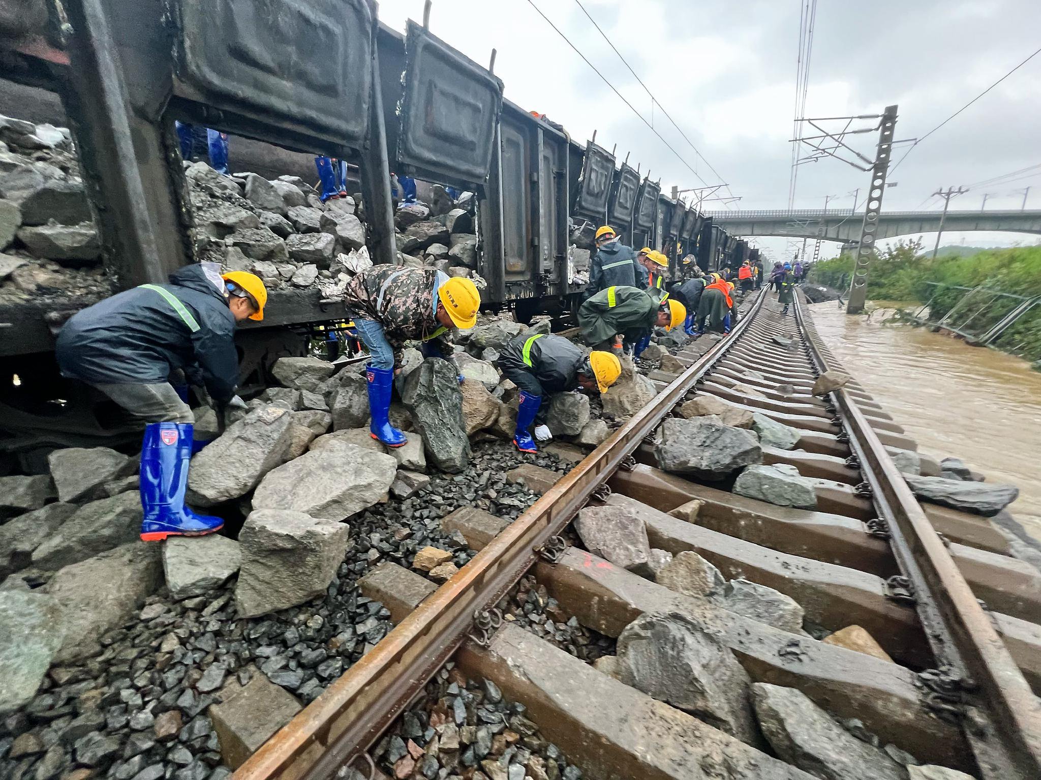 中铁二十二局一公司抢险人员在黑龙江省尚志市滨绥铁路水害路段运卸块石,填补加固塌方处路基。