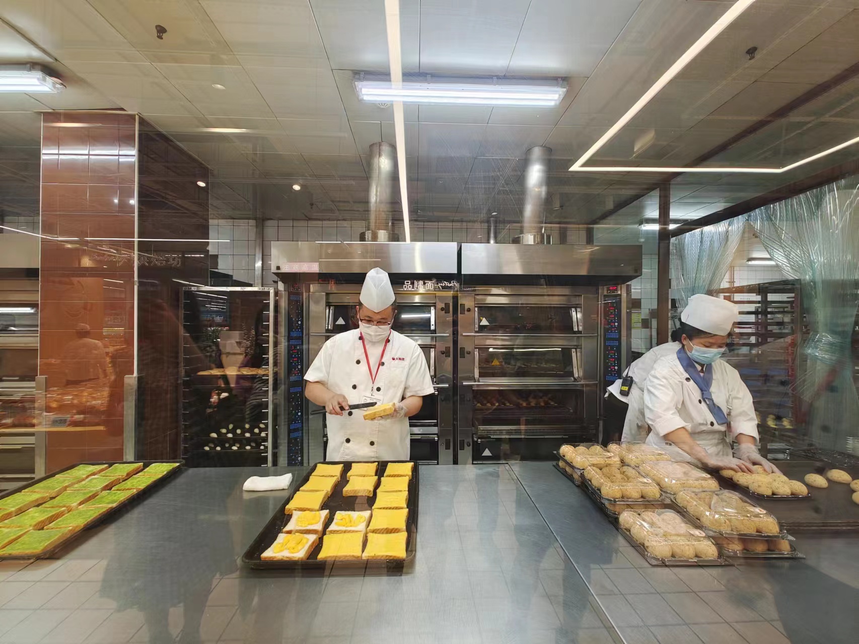 烘焙师傅正在包装、切片、脱模。劳动报记者陆燕婷 摄影