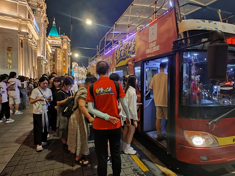 都市观光巴士外滩站点游客排队上车。李宝花摄