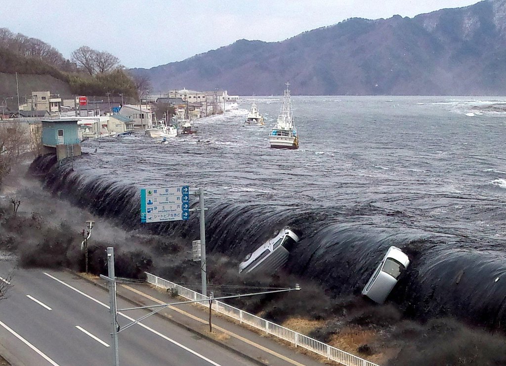 △2011年3月11日拍摄的照片显示,日本东北部海域发生9.0级地震后不久,海啸冲破堤坝并涌入岩手县宫古市。