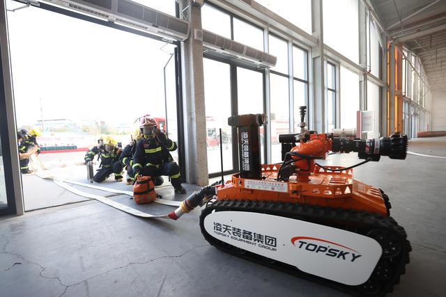 消防员操控消防坦克进入现场。 新京报记者 王飞 摄