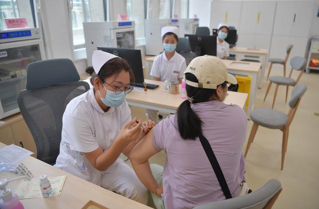 荣华社区卫生服务中心接种台,医护人员在为患者注射疫苗。  新京报记者 李木易 摄