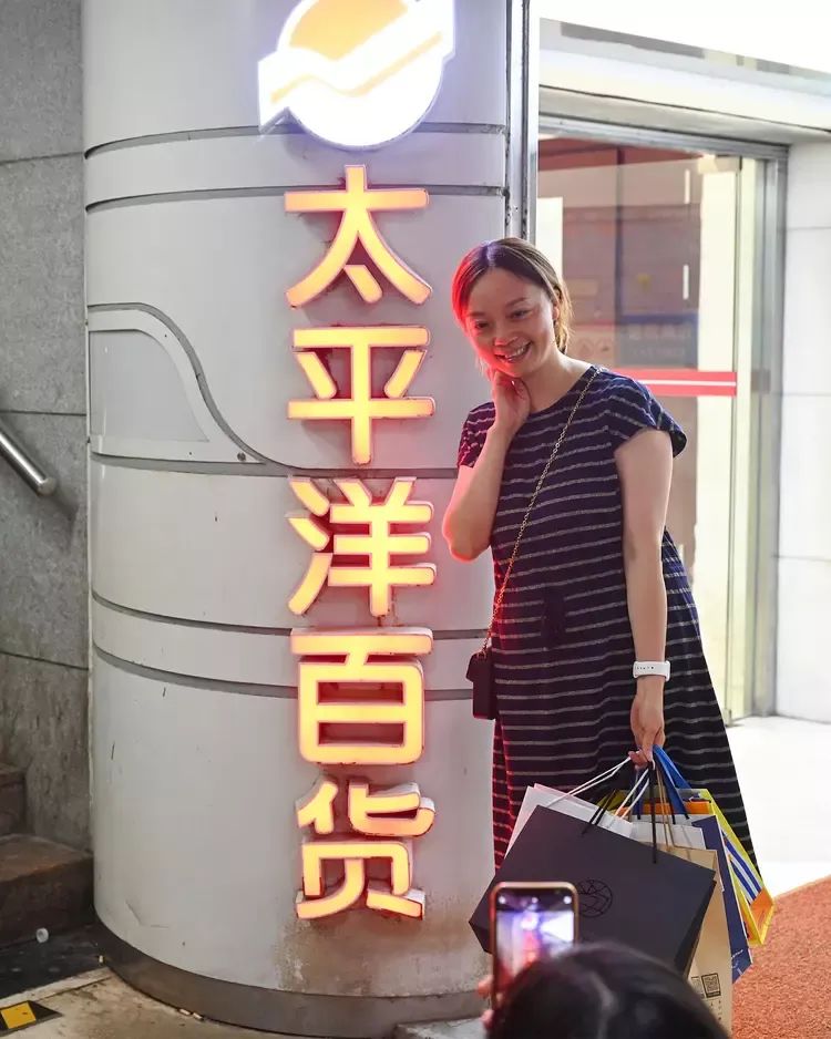 2023年8月27日，林女士在上海地铁一号线徐家汇站通往太平洋百货负一层的广告灯前留影。澎湃新闻记者 吴栋 图