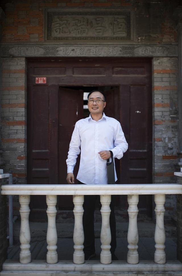 张志勇在恒昌瑞记的门联匾额砖雕前。新京报记者 王贵彬 摄