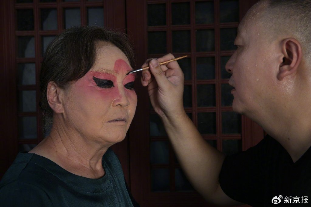 8月16日,丁石锁的徒弟邱振飞正在为“三只船”表演者化妆。新京报记者 尹亚飞 摄