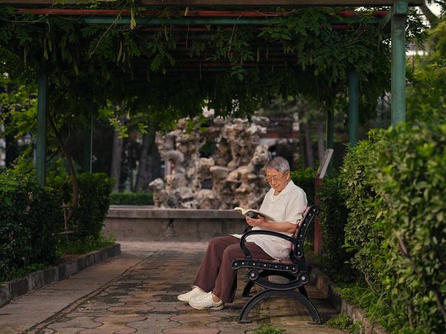 王道成在小区里读书。新京报记者 郭延冰 摄