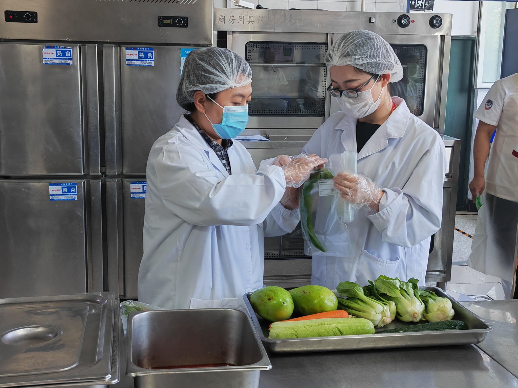工作人员对学校食堂食谱上的菜品原料进行取样。王文郁/摄