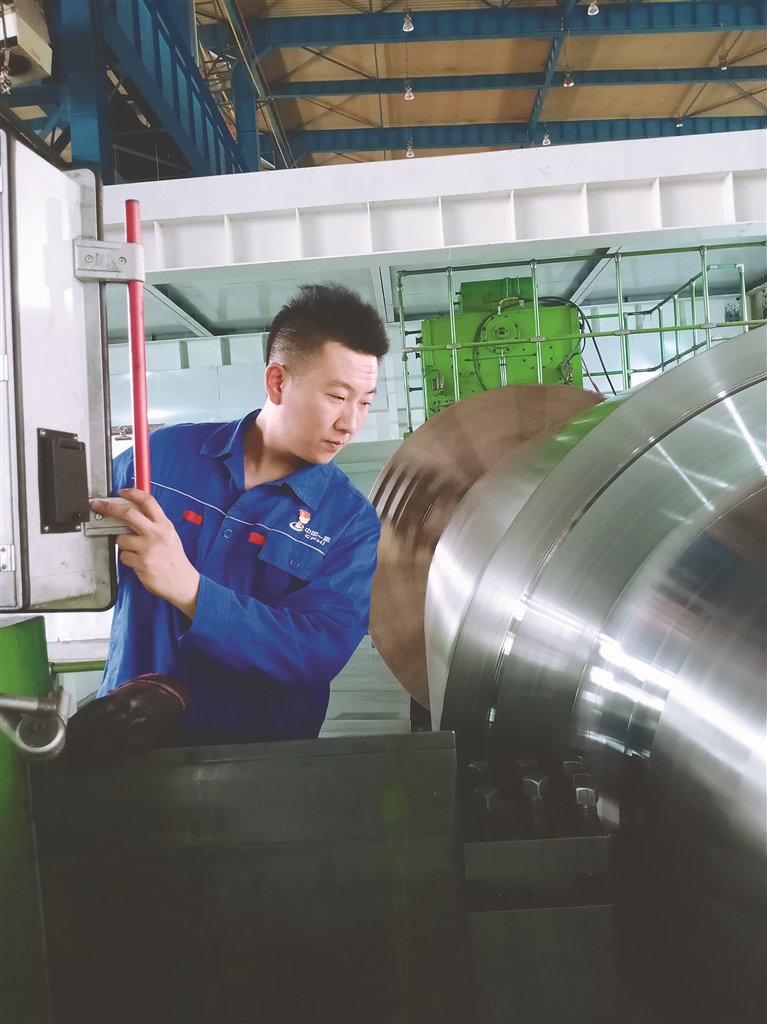 轧电制造厂数控400T机床青年操作者王宏琪在工作中。