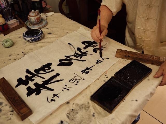 2023年8月9日,牛玉亮在写毛笔字。新京报记者 郭延冰 摄