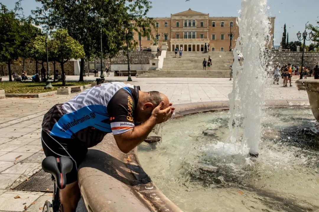 7月12日，在希臘首都雅典，男子在噴泉處洗臉納涼。新華社發（帕納約蒂斯·莫斯卡德里歐攝）