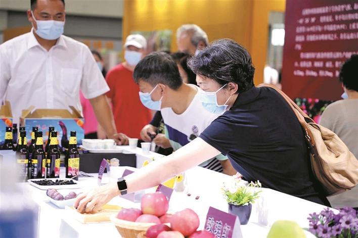 天津市援十一师工作组在天津梅江会展中心“天津市消费帮扶月”上推广兵团农副产品。图为参展者在挑选产品(资料图片)。王瑜 摄