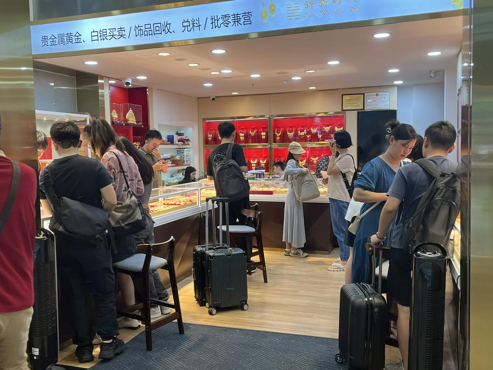 (拎着箱子来水贝进货的代购、商家 财联社记者摄)