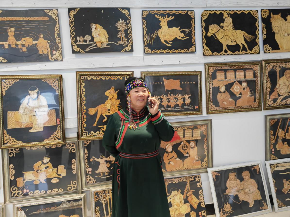 图为呼玛白银纳乡鄂伦春族桦树皮镂空画非物质文化遗产传承人关桃芳用5G手机与远方亲人通话。