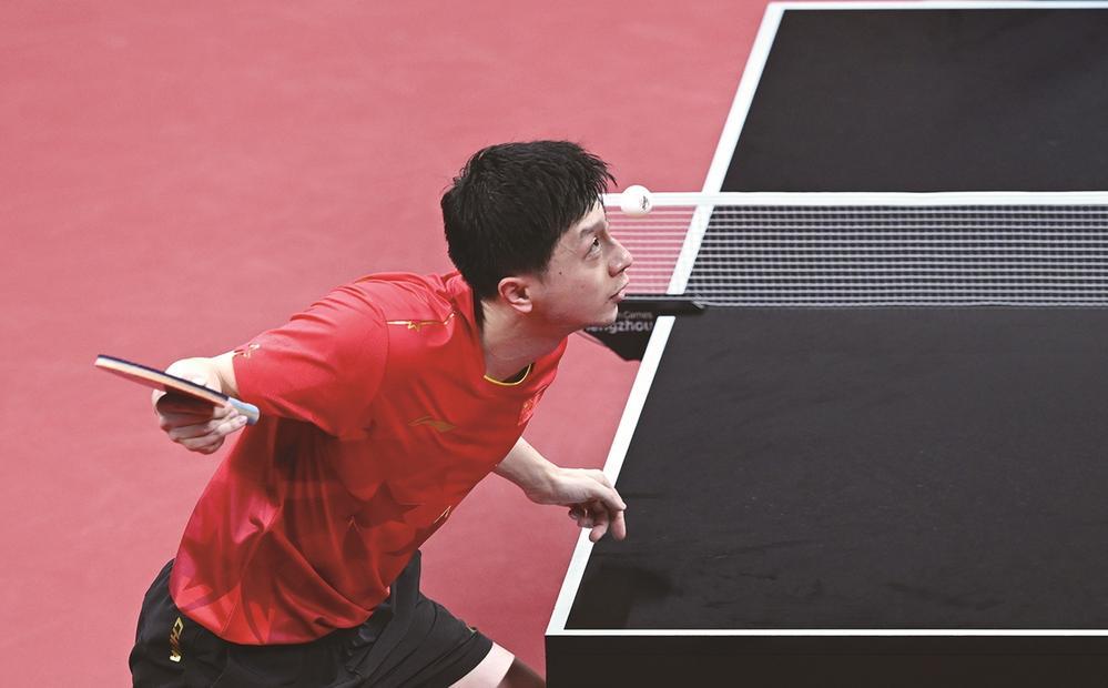 在杭州亚运会乒乓球男团决赛中。中国队以3-0击败韩国队，取得八连冠。图为中国选手马龙在比赛中发球。