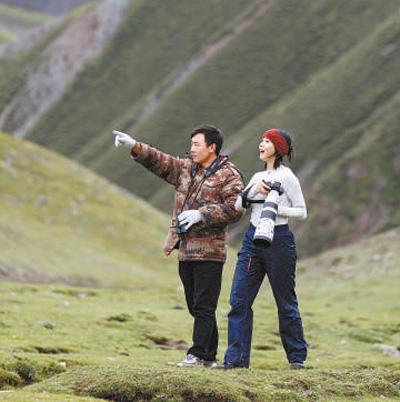 在位于三江源国家公园澜沧江源园区的昂赛大峡谷,牧民桑周(左)带领自然体验者拍摄野生动物。周梦爽摄