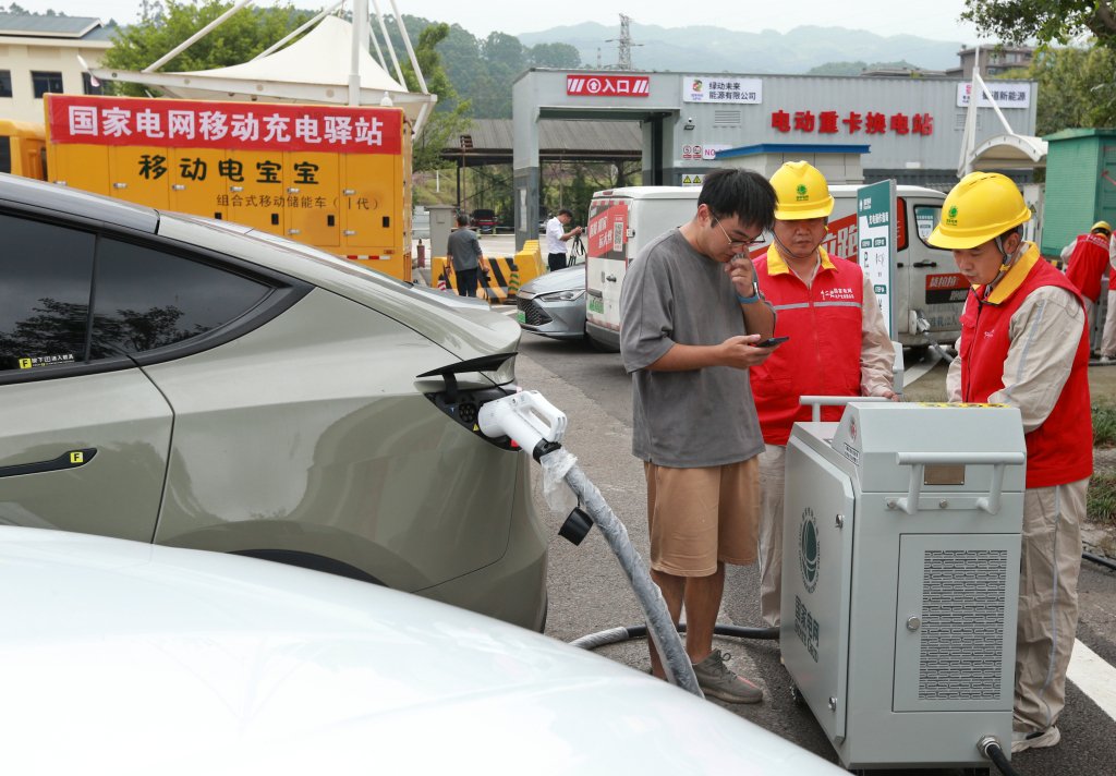 工作人員向司機介紹移動充電樁。國網重慶永川供電公司供圖