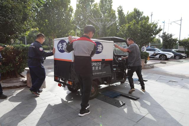 工作人员使用便携式机动车检测专用称重仪进行车辆称重。新京报记者 裴剑飞 摄