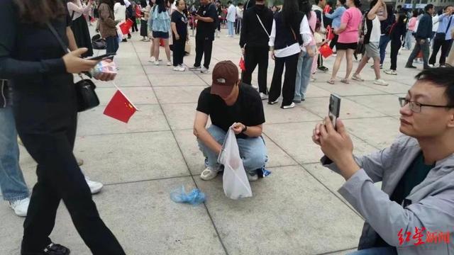 ▲升旗仪式结束后，市民自发留下捡垃圾