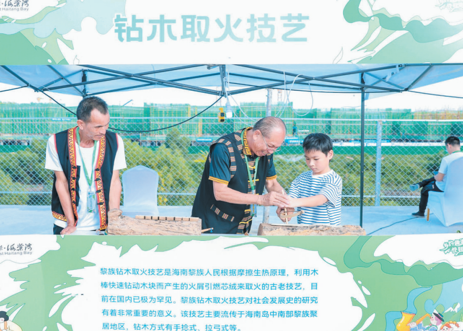 ▲在2023年三亚市海棠区乡村文化旅游节活动现场,小朋友体验钻木取火技艺。陈聪聪 摄