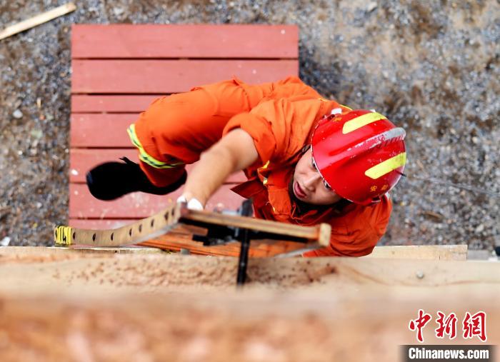 消防员在参加消防运动会攀登挂钩梯操项目。王金秋 摄