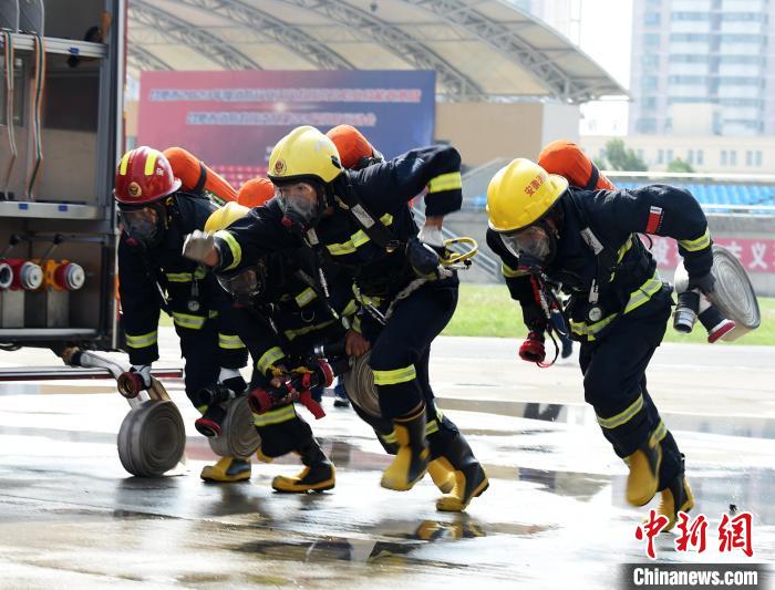 消防員在參加消防運動會百米負重項目。王金秋 攝