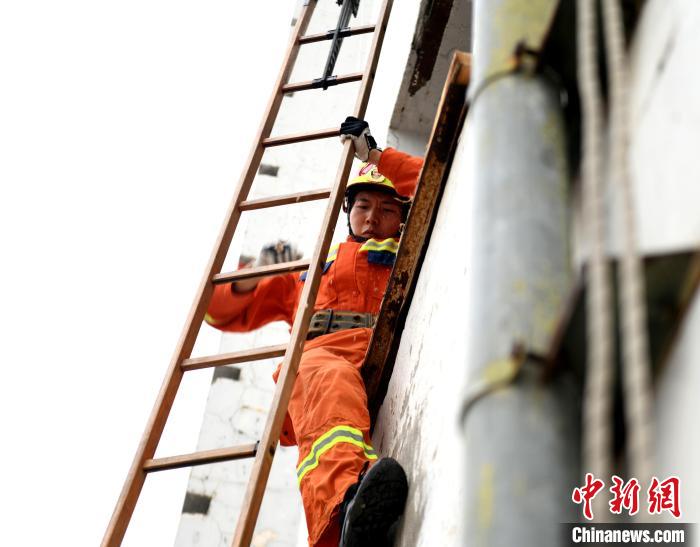 消防员在参加消防运动会攀登挂钩梯操项目。王金秋 摄