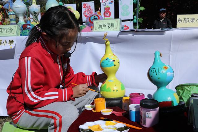 密云区学生劳动素养展示中，学生在画葫芦。图/北京教育融媒体中心