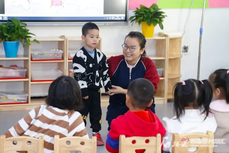 10月25日,在经开向上第二幼儿园,老师教小朋友唱儿歌。石榴云/新疆日报记者谢龙摄