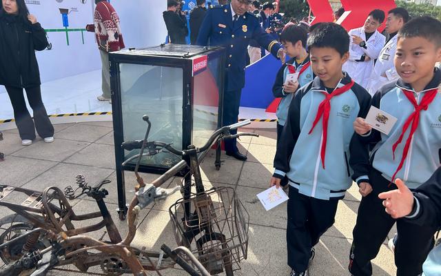 小学生参观起火后的电动车。新京报记者 彭镜陶 摄