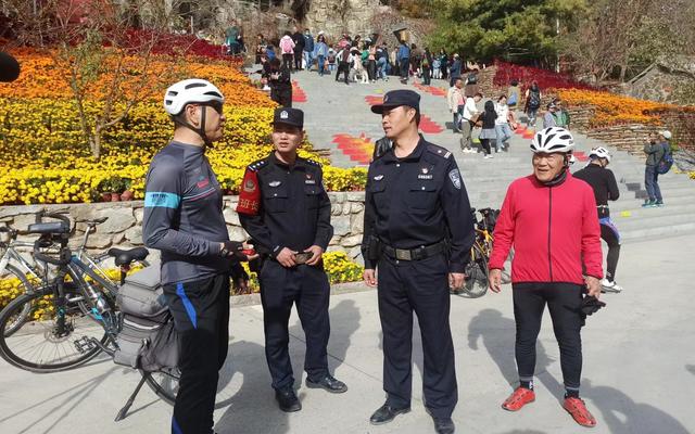 执勤民警向游客宣传游玩安全知识。新京报记者 吴梦真 摄