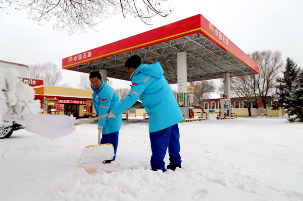 加油站员工清理积雪保障站点正常运营