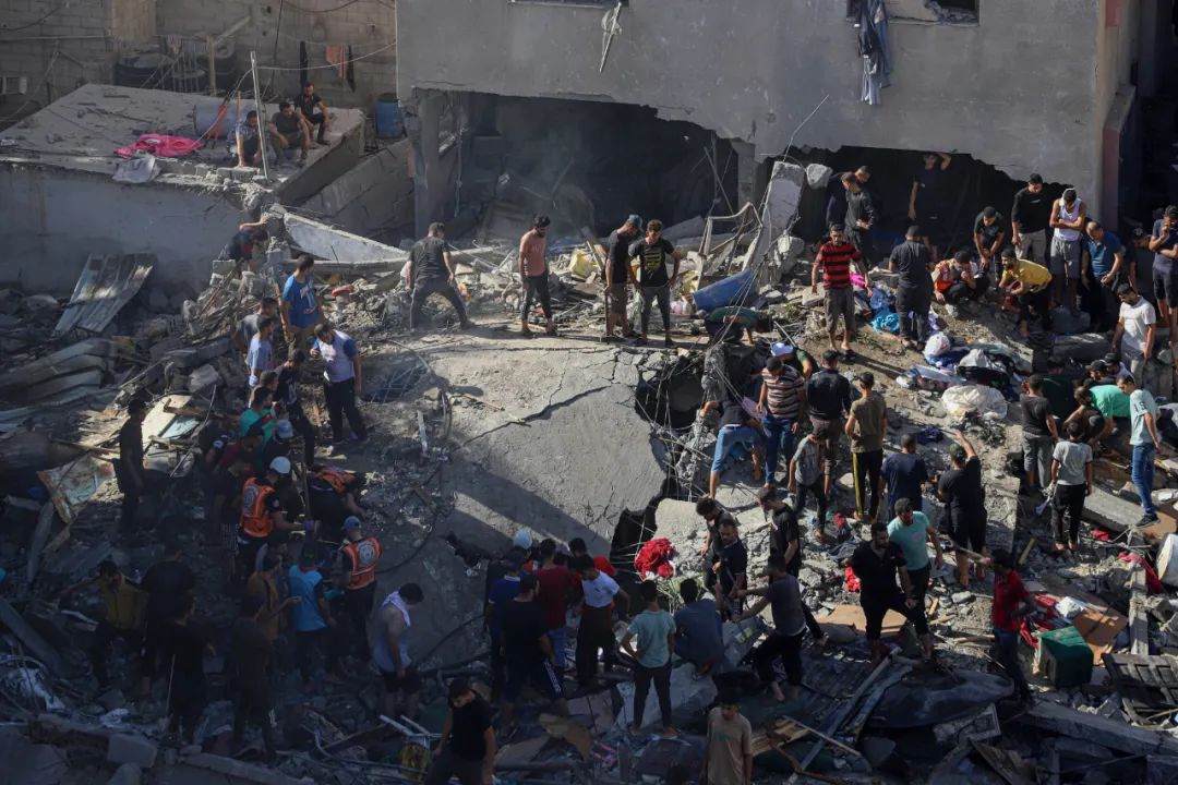 11月6日，人們在加沙地帶南部城市汗尤尼斯的一處廢墟上搜救。 新華社發（里澤克·阿卜杜勒賈瓦德攝）