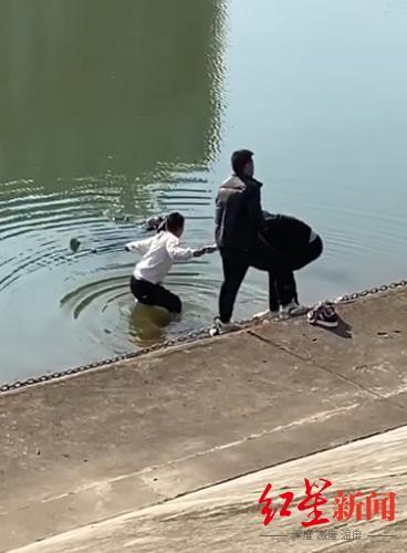 ▲张先生(白衣男子)在众人协助下救落水儿童