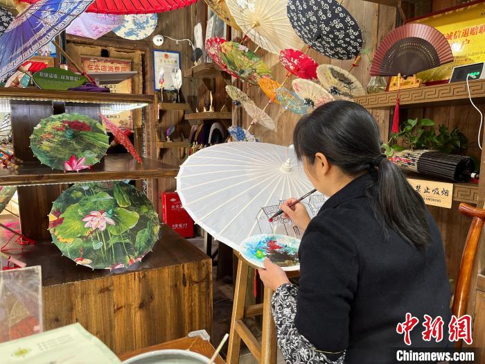 11月18日，曹文娟正在江西婺源篁嶺天街的店內繪傘。李韻涵 攝
