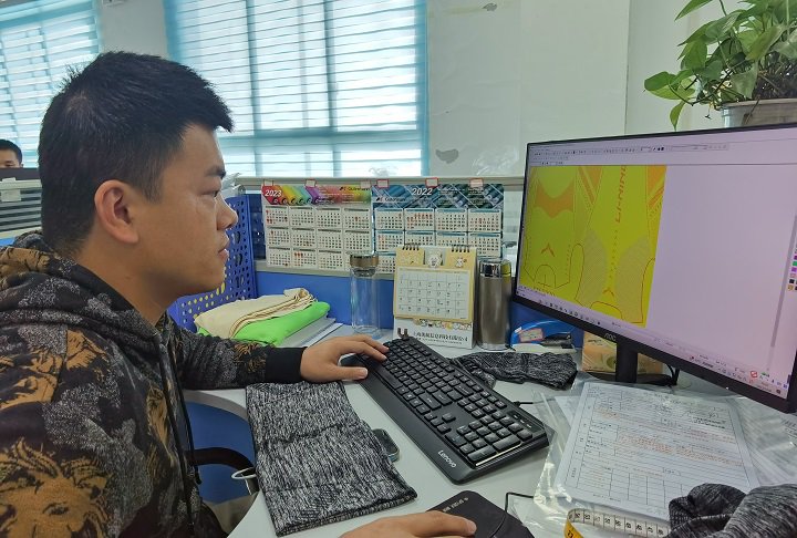 贵州鼎盛服饰有限公司程序设计师韩小飞为车间设备编写作业程序。管云 摄