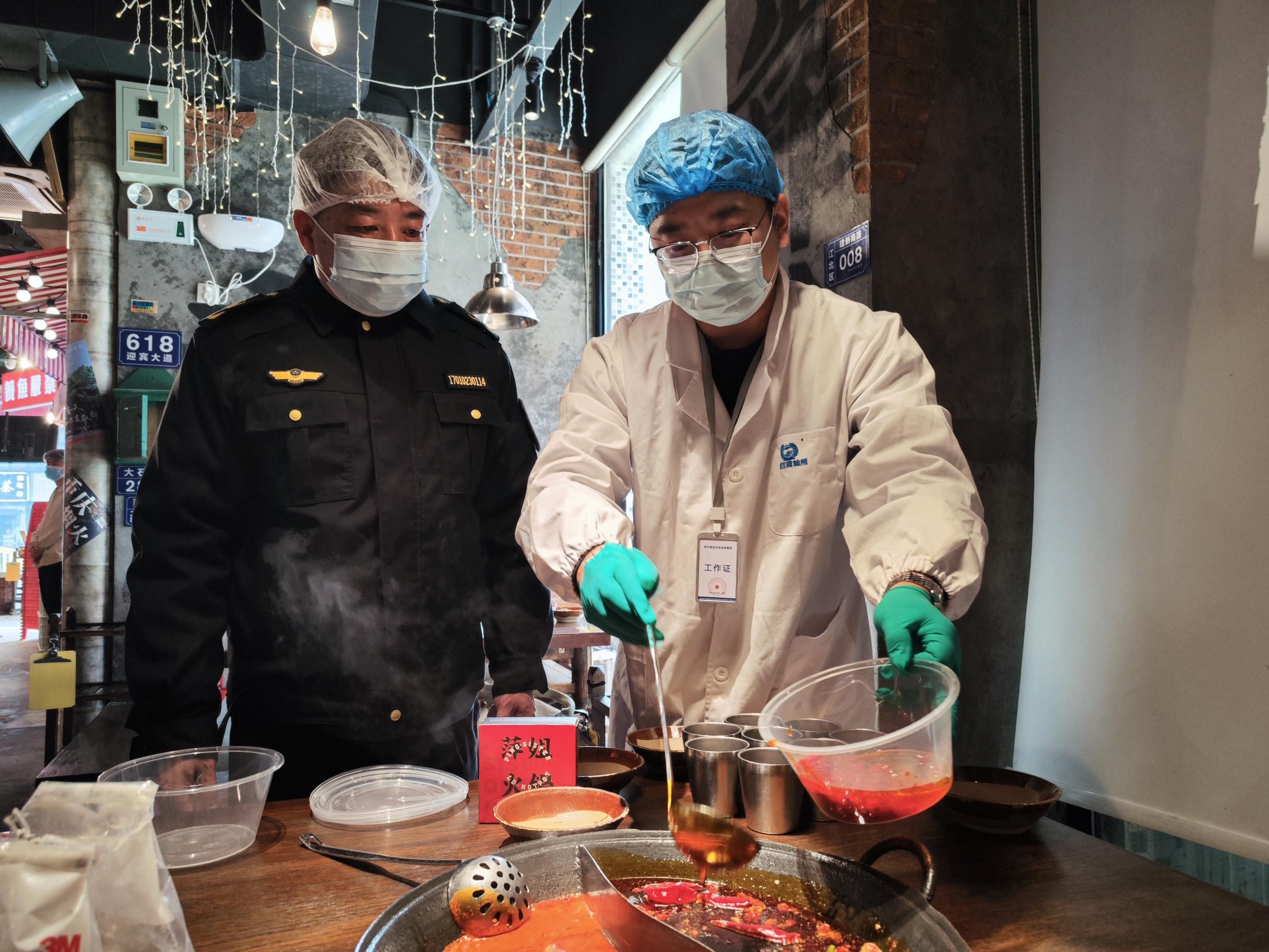 市场监管执法人员和抽检员现场对火锅底料进行抽样。吴采平摄
