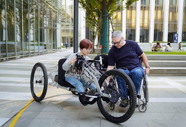 圖說：大程子（左）在上紐大校園首次嘗試祖伊斯的輪椅山地車