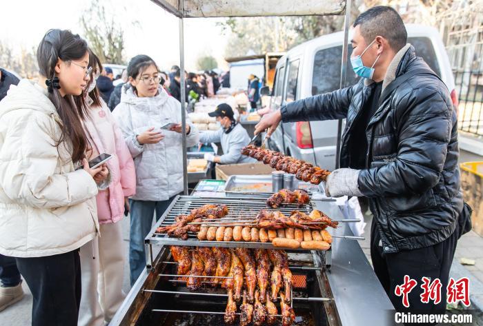 12月3日上午，來自天津城建大學的三位大學生正在「姚村大集」上購買烤雞腿。王在禦 攝