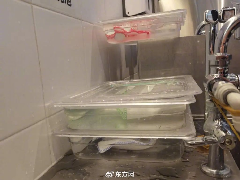 △门店装有红、绿、蓝三色消毒抹布的消毒水浸泡盒(图片来源:记者)