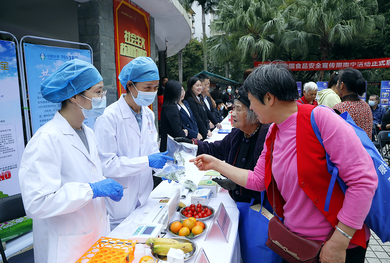 南宁市食品药品检验所工作人员为群众免费进行蔬菜、水果等农药残留项目快速检测。(何正君 摄)