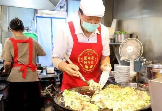 台北宁夏夜市内的圆环边蚵仔煎店老板赖炳勋在做蚵仔煎 图:中新社