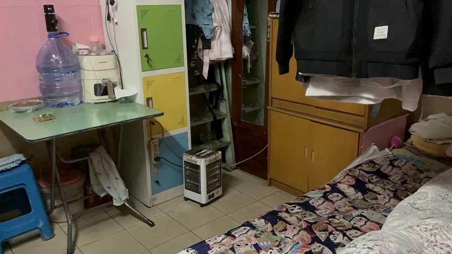 干洗店通道后面,床铺、衣柜等生活用品“一应俱全”(吕佳 摄)