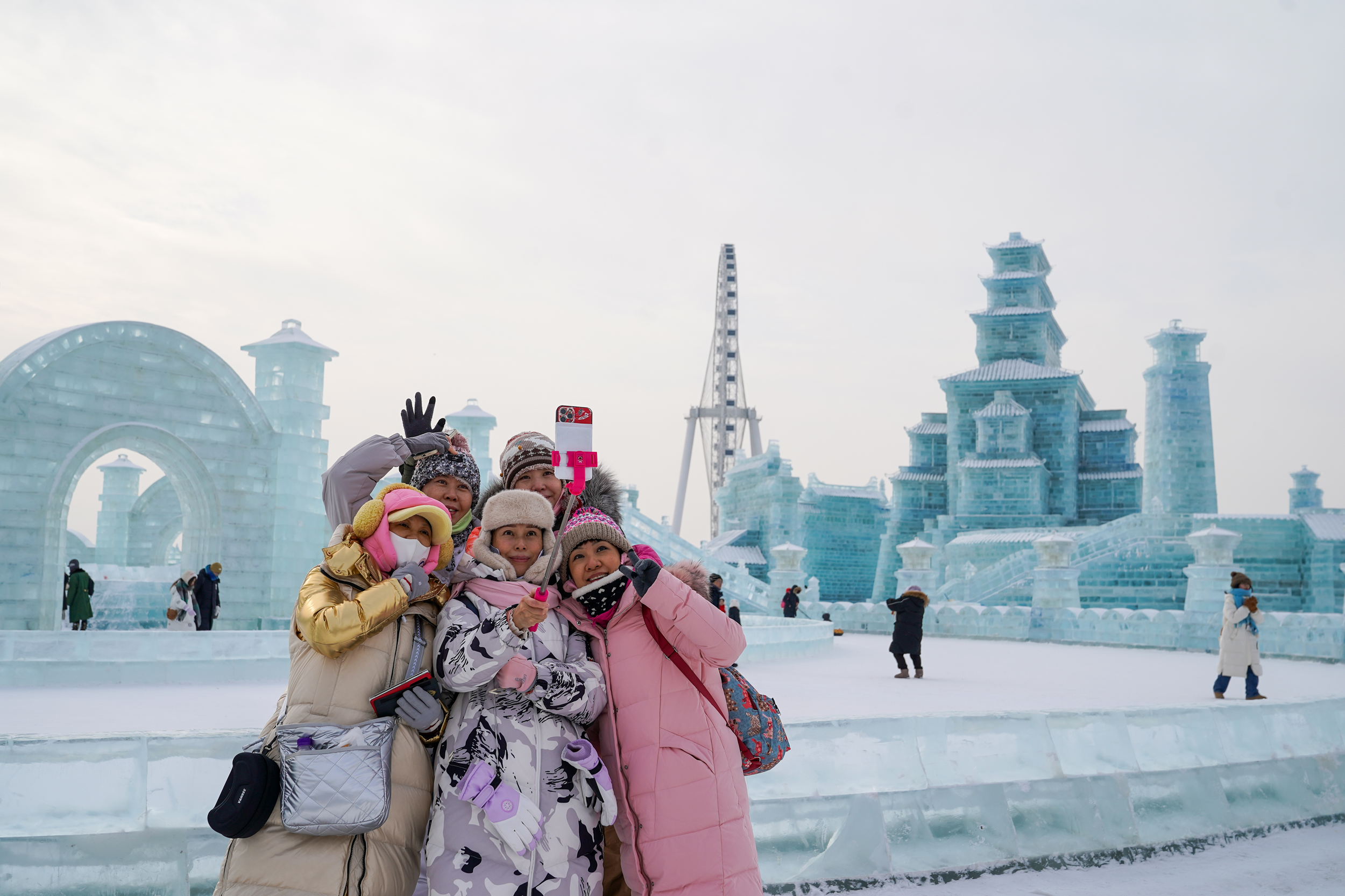 1月4日,第25届哈尔滨冰雪大世界内的冰雕吸引游客观看。图为来自北京的游客“打卡”拍照。(图片由CNSPHOTO提供)