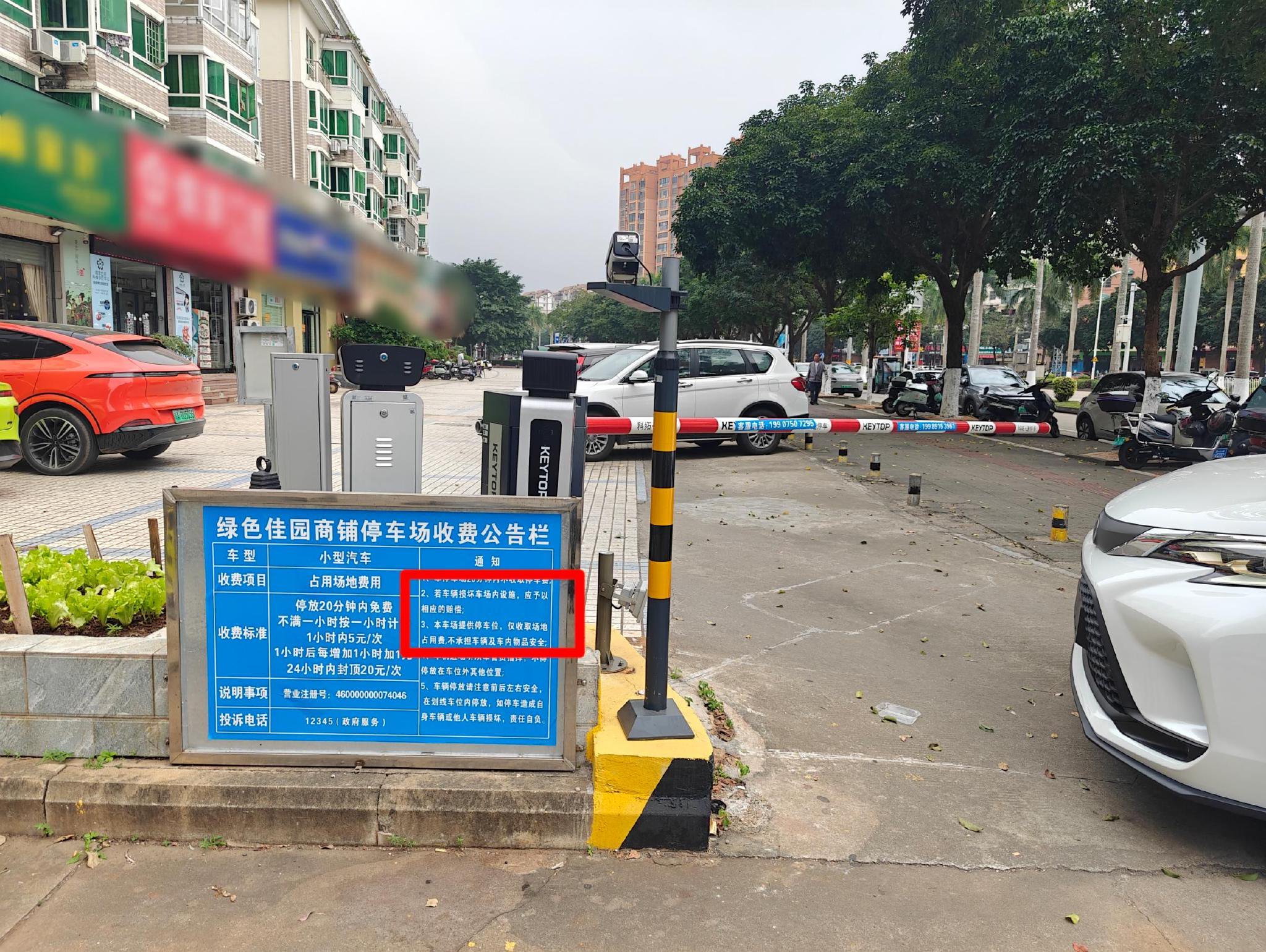 绿色佳园商铺停车场收费公告栏上声明不承担车辆和车内物品安全。记者 姜飞 摄