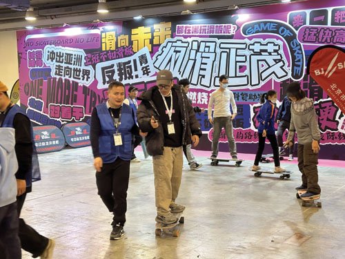 图为观众正在体验陆地冲浪电动滑板。