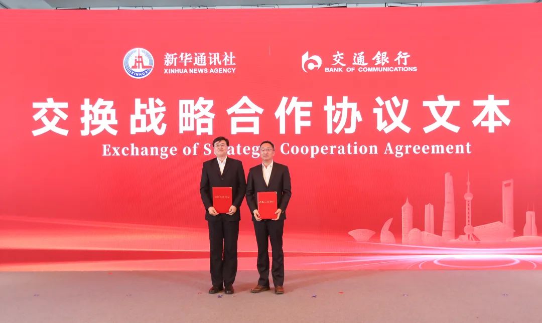 图为新华社党组成员、秘书长景如月与交通银行党委副书记、行长刘珺交换合作协议文本。