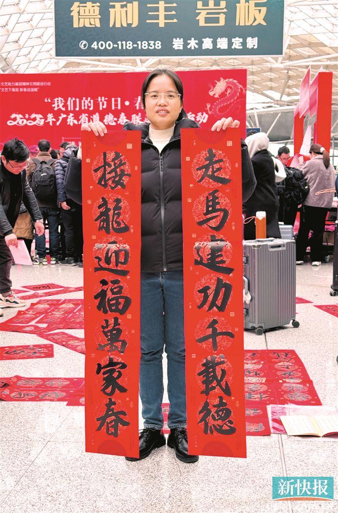1月26日,雷女士在广州南站参加“2024年广东省道德春联进万家活动”,领取了两副春联。新快报记者 夏世焱/摄