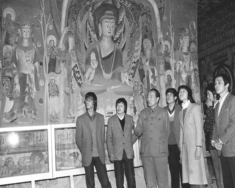  1987年，時任敦煌研究院院長段文傑（左三）向年輕大學生介紹敦煌石窟壁畫藝術。 新華社記者 張生貴 攝