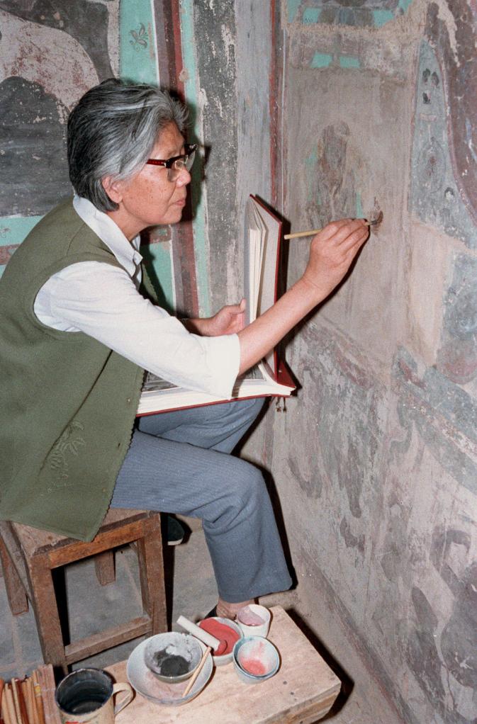 1989年，時任敦煌研究院美術研究所副所長李其瓊正在精心描繪複原在原壁上的被盜壁畫。新華社記者 李生才 攝